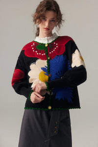 Damen Strickjacke mit Knopfleiste und Blumenmuster in Reliefstruktur sowie Bogensaum in Schwarz